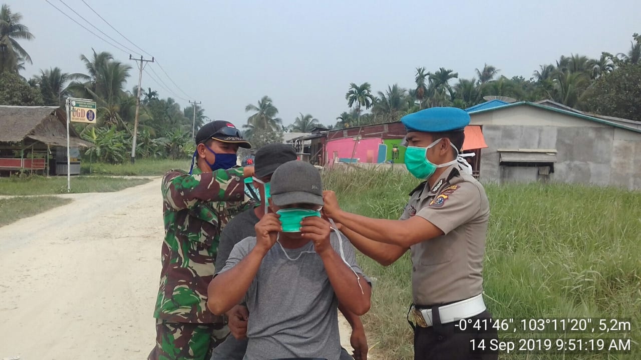 Meminimalisir Dampak kabut asap Babinsa koramil 07/Reteh ikut bagikan masker.