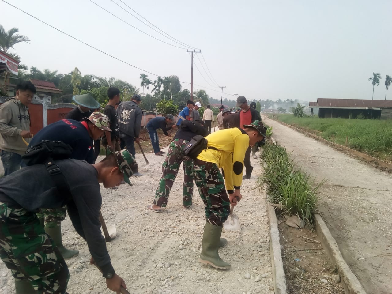 Satgas TMMD bersama Masyarakat Serakkan Sirtu yang di Angkut Oleh Mobil DamTruk