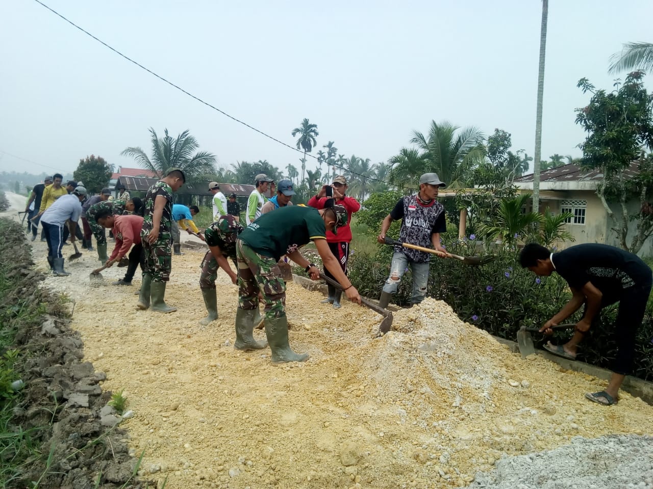 Sambil bekerja melakukan penimbunan jalan dengan sirtu