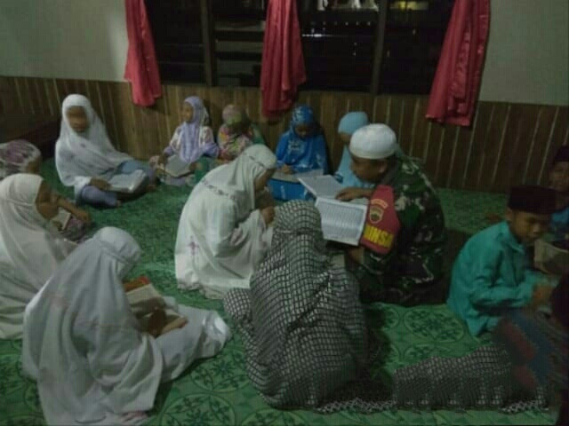 Babinsa Desa Simpang Gaung mendampingi baca Al-Qur'an bersama dalam kegiatan Magrib mengaji