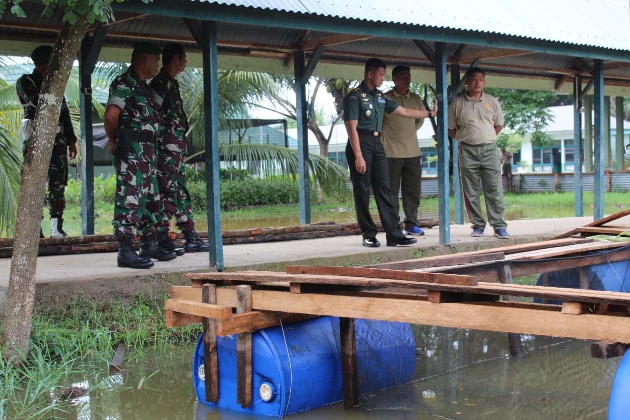 Anggota Staf Teritorial Kodim 0314/Inhil melakukan gotongroyong membuat keramba ikan