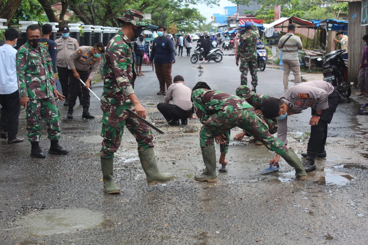 Kodim 0314/Inhil bersama Polres Inhil dan organisasi PSMTI, melaksanakan perbaikan atau penambalan jalan berlubang di dua titik