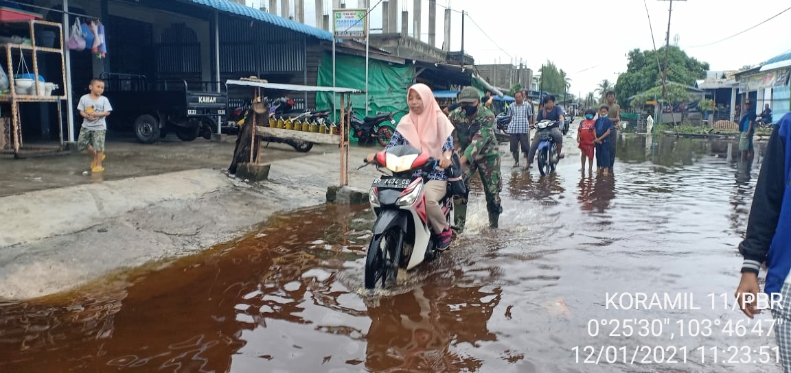 Babinsa Koramil 11/Pulau Burung Kodim 0314/Inhil Membantu Pengguna Jalan di Masa Pasang. Besar dan Hujan