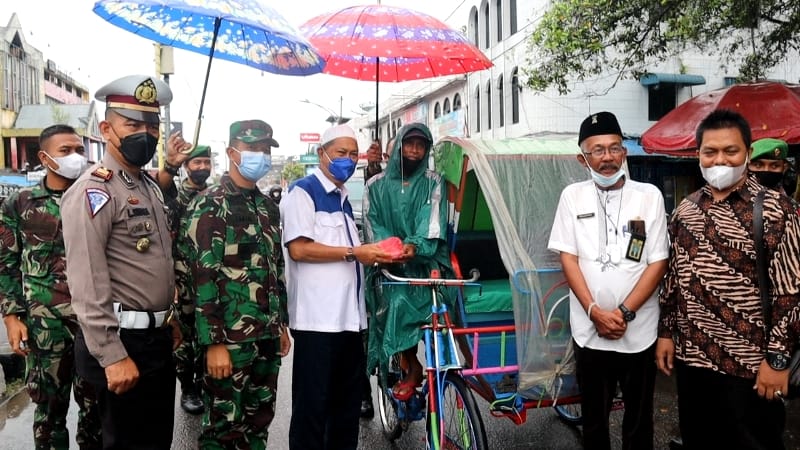 Di Tengah Rintik Hujan, Pak Imir dan Pak Marlis Bagikan Sarapan Pagi